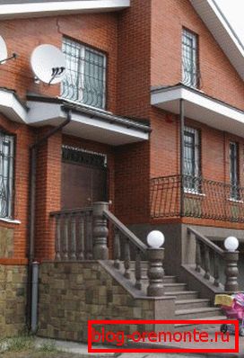 Concrete porch with wooden railing lined with stone Concrete porch with wooden railing lined with stone