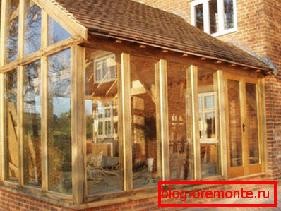 It looks interesting glass combined with wooden supports - this is an extension to the brick house