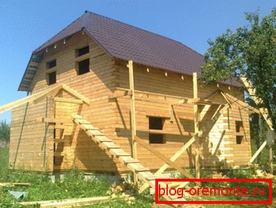 Amateur photo of a two-story wooden house of bars with dimensions of 9 by 9 Amateur photo of a two-story wooden house of bars with dimensions of 9 by 9