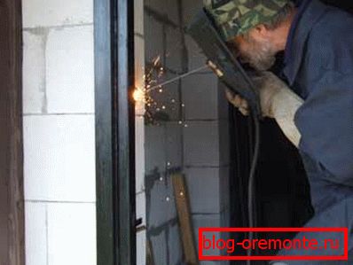 Welding metal pins to the door frame installation of metal entrance doors