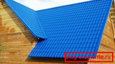 In this photo of a bar-shaped house, the metal tile of a bright color scheme serves as a roofing flooring. In this photo of a bar-shaped house, the metal tile of a bright color scheme serves as a roofing flooring.