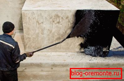 In the photo - applying a layer of bitumen mastic In the photo - applying a layer of bitumen mastic