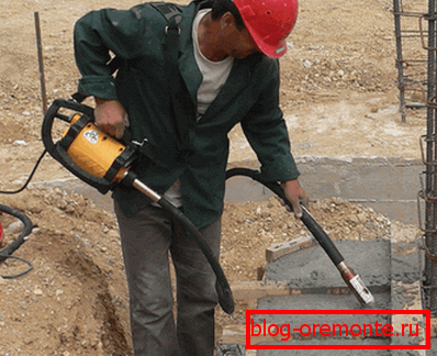 In the photo - using a portable vibrator for concrete