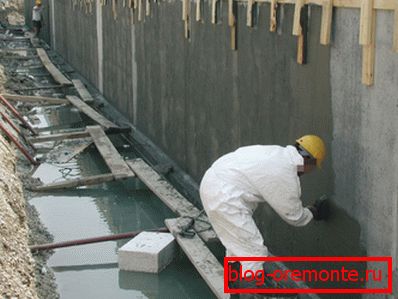 Applying a waterproofing mix to a concrete wall Applying a waterproofing mix to a concrete wall