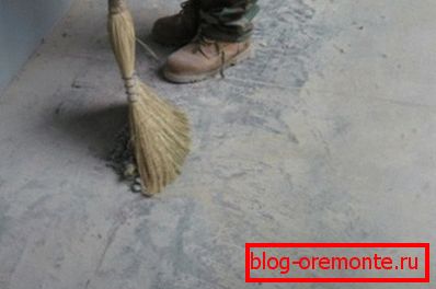 Dusting the concrete floor with your own hands and a broom Dusting the concrete floor with your own hands and a broom