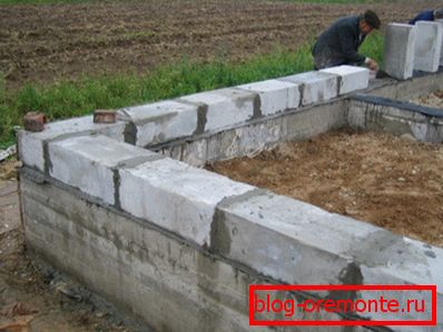 Installing the first row of foam block on a concrete strip foundation Installing the first row of foam block on a concrete strip foundation