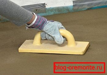Grouting concrete floor manually with a plastic grater